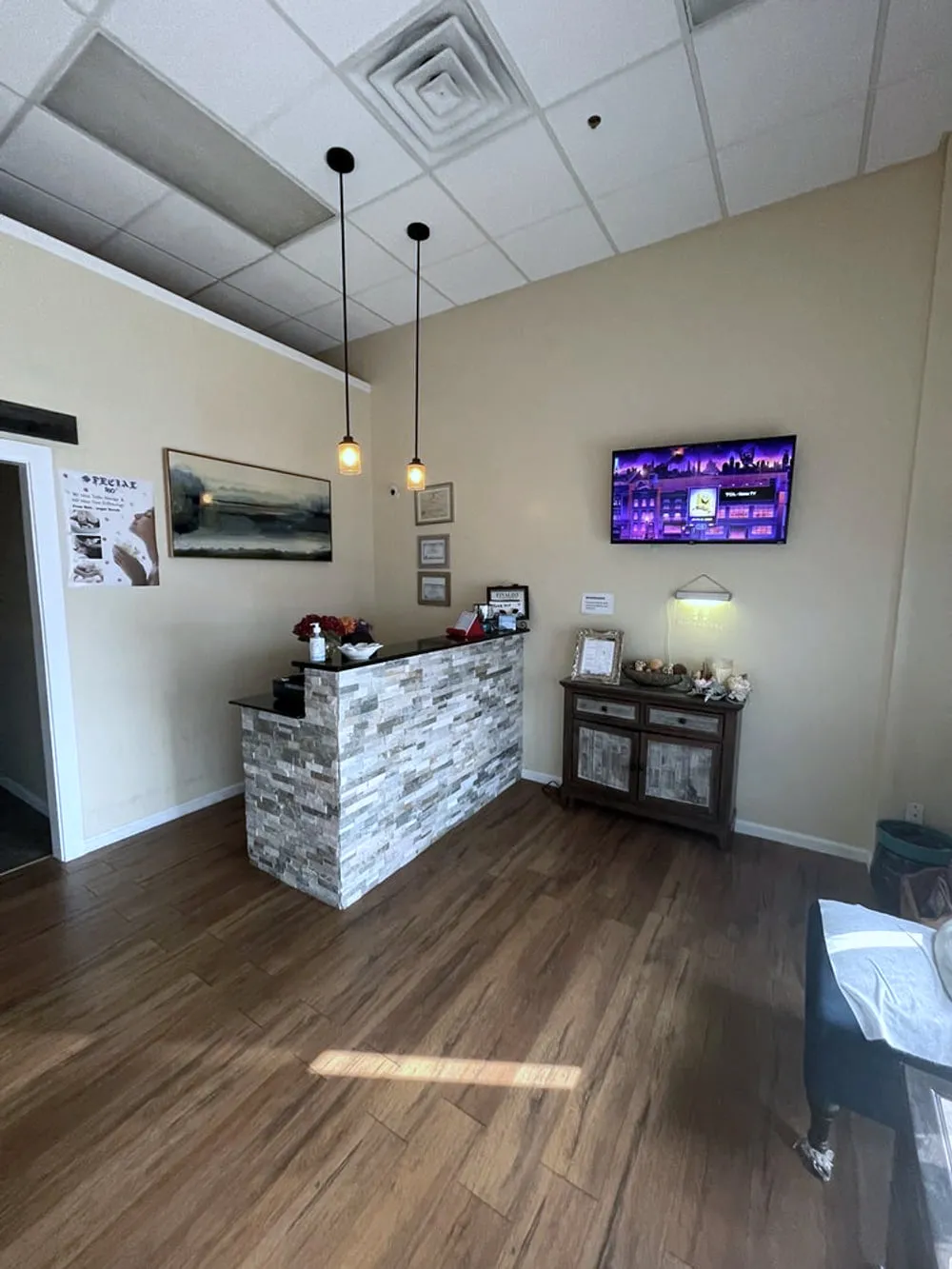 The front desk at LJY Reflexology in Hermitage, with pendant lights over a stone-clad counter